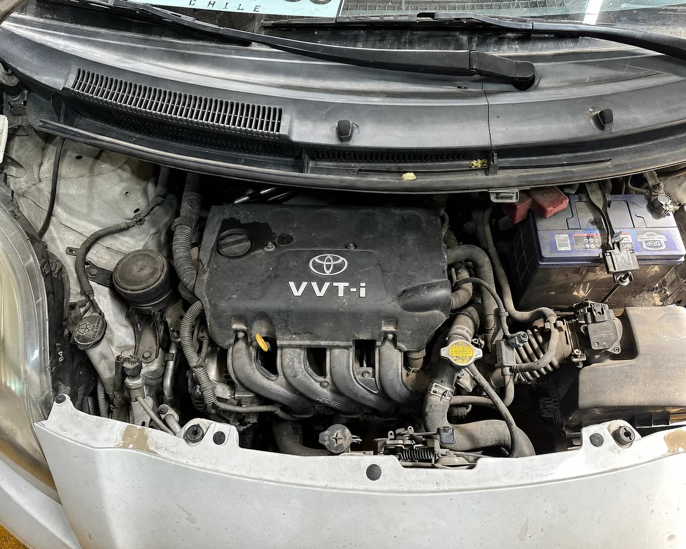 Motor Toyota con polvo y suciedad visible antes del servicio de limpieza